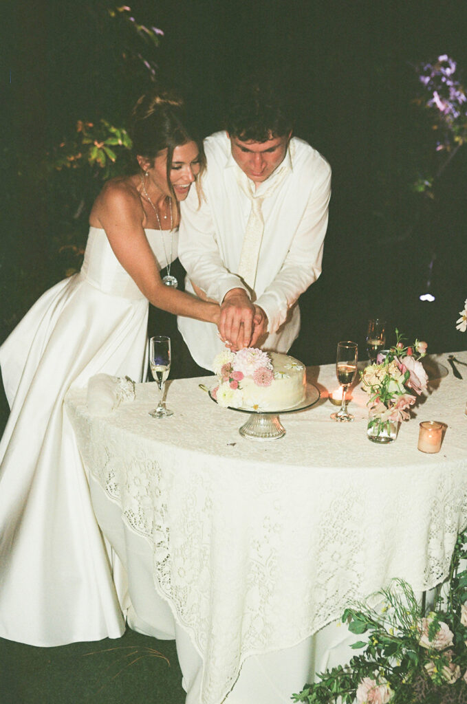 Couple cutting their floral wedding cake