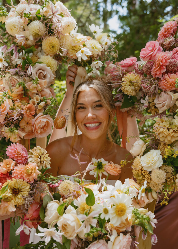 Woman smiling behind colorful bouquets